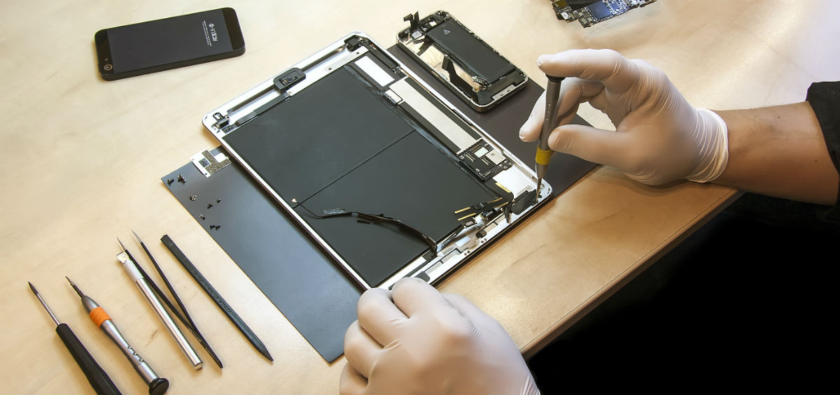 En tekniker arbejder med reparation af en tablet